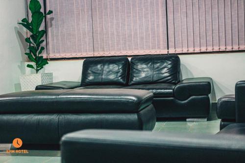 a black leather couch in a living room at 5 PM Hotel in Nairobi