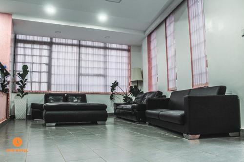 a waiting room with black leather furniture and windows at 5 PM Hotel in Nairobi