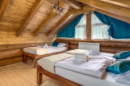 - une chambre avec 3 lits dans une maison en bois dans l'établissement Loghouse Madeira, Fužine., à Fužine