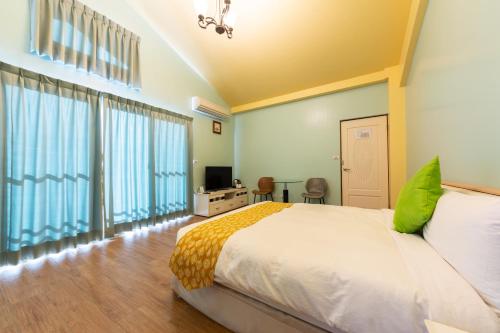 a bedroom with a bed and a tv and some windows at 光腳丫宜蘭民宿 in Dongshan