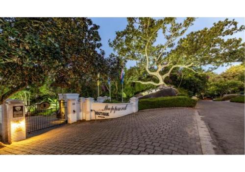 a fence in front of a cemetery with a tree at Sheppard Boutique Hotel in Nelspruit