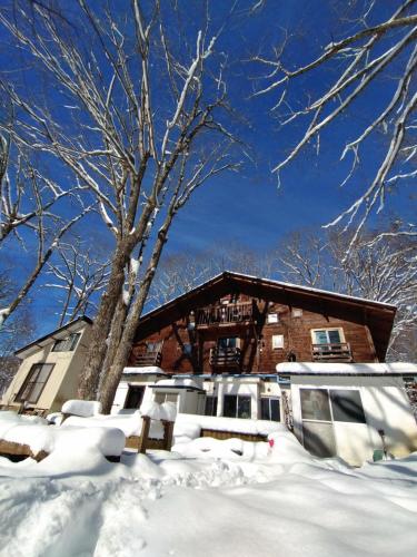 北塩原村的住宿－ペンションとも，雪中一棵树的房子