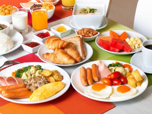 a table with plates of breakfast food on it at ibis Bangkok Siam in Bangkok