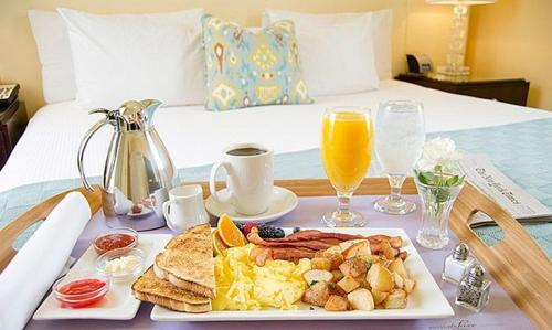 a breakfast tray with a plate of food on a bed at Hotel Airport inn plaza near delhi airport Aerocity in New Delhi