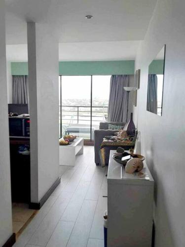 een woonkamer met een keuken en een woonkamer met een bank bij Appartement avec piscine Anse Vata Nouméa in Noumea