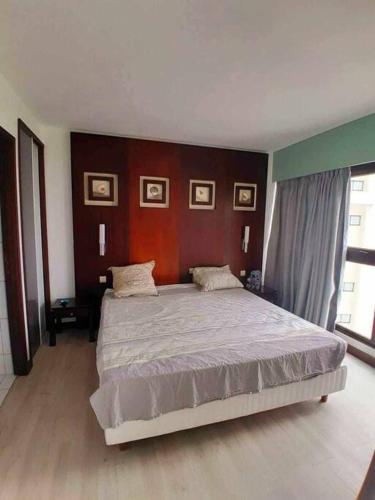 una camera con un grande letto di Appartement avec piscine Anse Vata Nouméa a Noumea