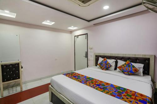 a bedroom with a bed with a colorful blanket on it at FabHotel Leaf Paradise in Lucknow