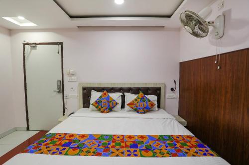 a bedroom with a bed with a colorful quilt on it at FabHotel Leaf Paradise in Lucknow