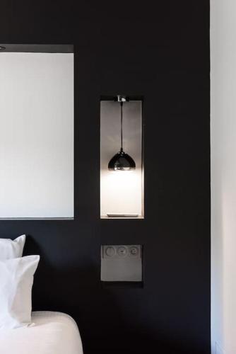 a black bedroom with a bed and a mirror at Le Loft in Libourne