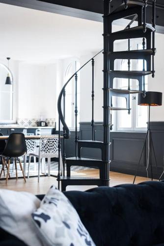 a living room with a staircase and a couch at Le Loft in Libourne
