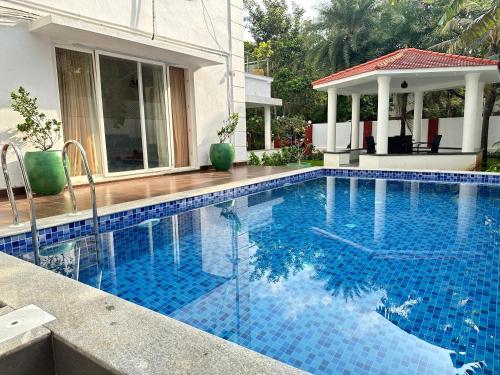 uma piscina com azulejos azuis numa casa em Villa Ithaka by Youkoso em Chennai