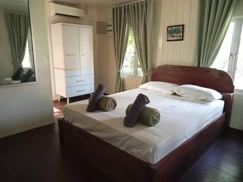 um quarto com uma cama grande com duas almofadas em Rumah D'Rhu, Zaki's Residence em Marang