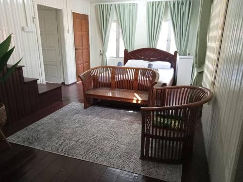 uma sala de estar com um sofá e uma cadeira em Rumah D'Rhu, Zaki's Residence em Marang