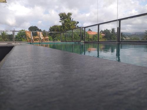 a pool of water with two chairs next to it at De Mansion Hotels in Katugastota