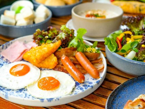 a plate of food with eggs and vegetables on a table at Mercure Bangkok Siam in Bangkok