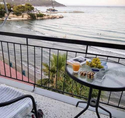 bandeja de comida en una mesa en un balcón con vistas al océano en Svetlana & Michalis Oasis Hotel, en Agia Marina Aegina