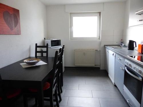 a kitchen with a black table and a table and chairs at Ferienwohnungen Yvonne Sigg in Rust
