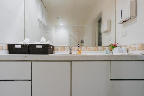 a bathroom counter with a sink and a mirror at Mountain Traveler Inn in Jiufen