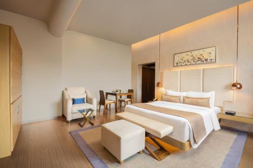 1 dormitorio con 1 cama, mesa y sillas en Fortune Hosur - Member ITC's Hotel Group, en Hosūr