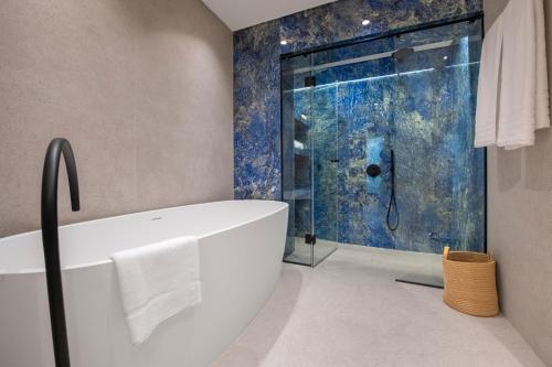 y baño con bañera blanca y ducha. en OPULENT PENTHOUSE 1, en Vari