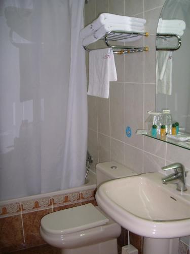 ein Badezimmer mit weißer Toilette und Waschbecken in der Unterkunft Hostal Centro Sol Madrid in Madrid