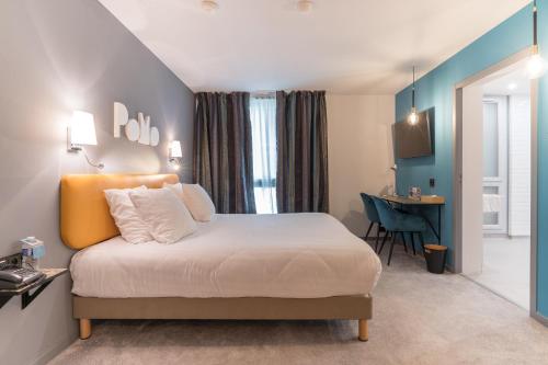 a hotel room with a bed and a desk at PoMo Hôtel & Restaurant in Échirolles