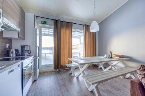 a kitchen with a table and benches in a room at Lomahuoneisto Skivillas 28 A 10 in Hyrynsalmi