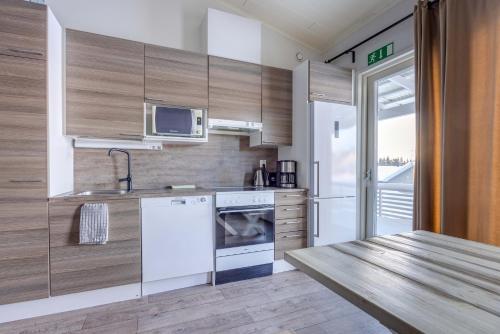 een keuken met een witte koelkast en een magnetron bij Lomahuoneisto Skivillas 28 A 10 in Hyrynsalmi