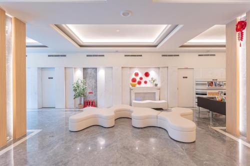 a living room with two white chairs and a table at Guide Hotel Kaohsiung Liuhe in Kaohsiung