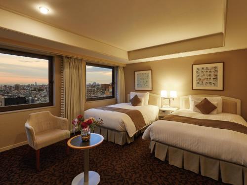 a hotel room with two beds and a window at Hotel Agora Osaka Moriguchi in Osaka