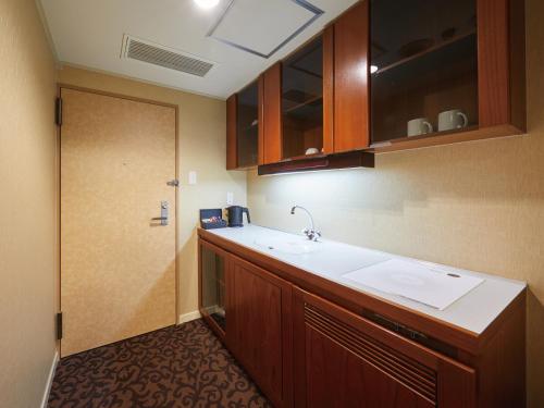 an empty kitchen with a sink and a door at Hotel Agora Osaka Moriguchi in Osaka