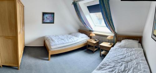 - une petite chambre avec 2 lits et une fenêtre dans l'établissement Ferienwohnung Alte Schule, à Winterberg