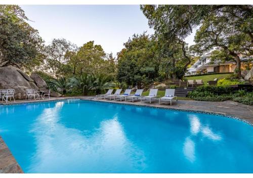 a swimming pool with lounge chairs in a yard at Sheppard Boutique Hotel in Nelspruit