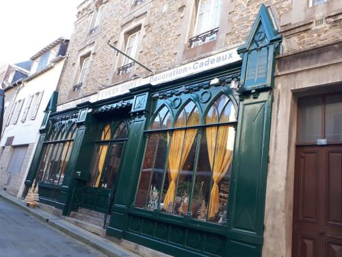 a green store front with yellow curtains in a street at Loft atypique hyper centre à 5mn à pied de la plage de l'Écluse 2 à 8 personnes in Dinard