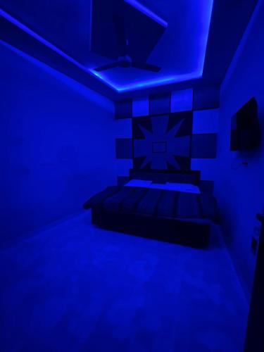 Habitación con cama con luces azules. en Ganpati hotal, en Amritsar