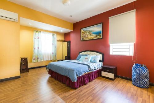 1 dormitorio con paredes rojas y 1 cama. en Cosy HomeStay at Penang Island -Beach and Village en Bayan Lepas