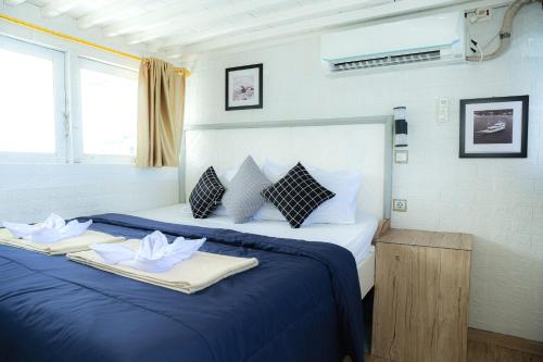 a bedroom with a blue bed with two towels on it at Arimbi Liveaboard in Labuan Bajo