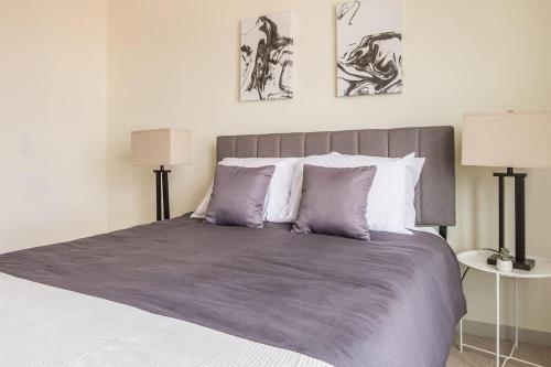 a bedroom with a large bed with purple sheets and pillows at TWO Stunning Nulu CozySuites in Louisville