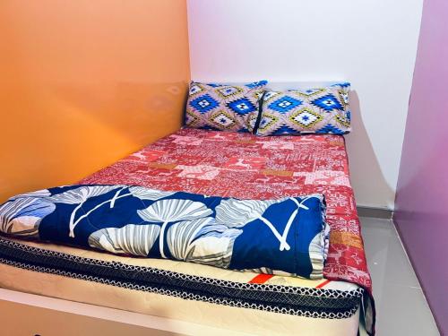 a small bed with a colorful comforter on it at Moon Backpackers Burjman Exit 2, Family Partitions, Loft partitions, in Dubai