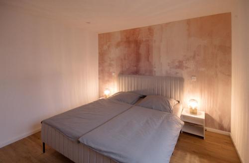 a bedroom with a bed with two lights on it at Casa Lorsch 1 in Lorsch