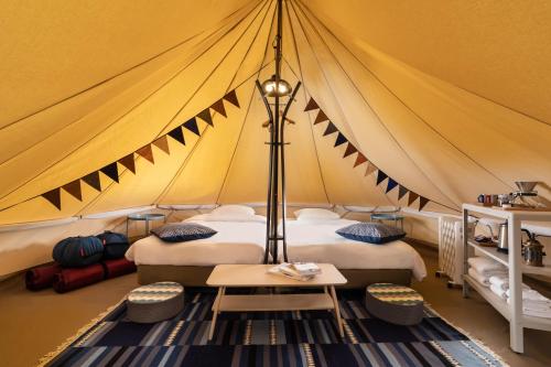 白馬的住宿－Laforet Glamping Field Hakuba，帐篷配有两张床和一张桌子