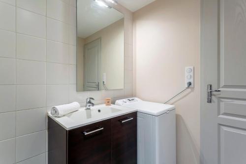 une salle de bain blanche avec un lavabo et un miroir dans l'établissement Appartmnt T2 Quai de Saône, à Lyon