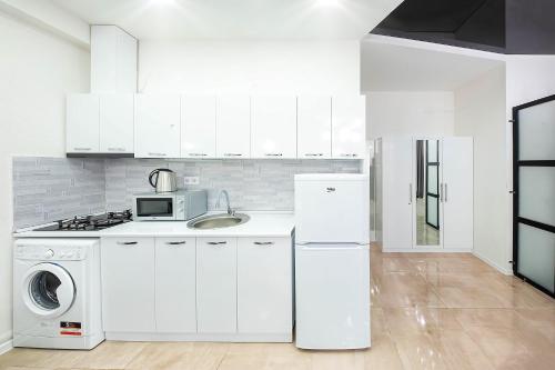 a white kitchen with a sink and a refrigerator at HB apartments Mitskevichi in Tbilisi City