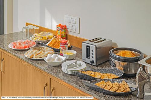 a kitchen counter with a buffet of food on it at Treebo Trend South Avenue 4 Min Walk From Promenade Beach in Pondicherry