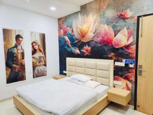 een slaapkamer met een groot schilderij van bloemen aan de muur bij HolidayVilla-A Residential Boutique Hotel-Newly Renovated in Amritsar