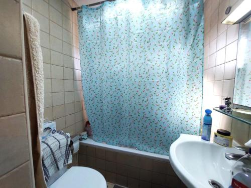 a bathroom with a shower curtain and a toilet and a sink at Manchester Tower in Dubai