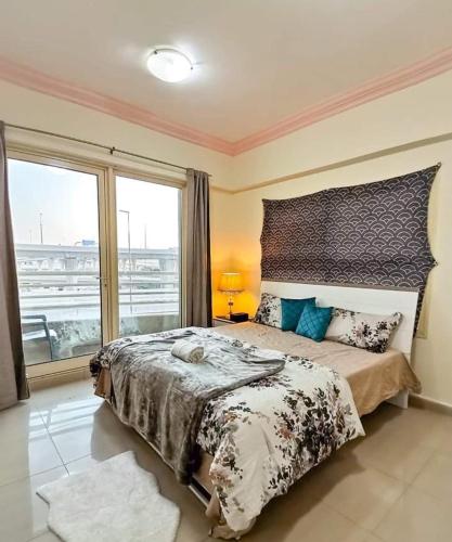 a bedroom with a large bed and a large window at Manchester Tower in Dubai