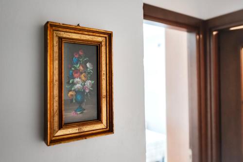 a painting of a vase of flowers on a wall at Dimora del borgo pittoresco in Cairo Montenotte