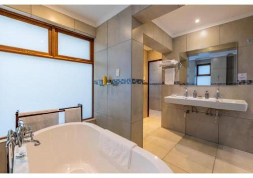 a large bathroom with a tub and a sink at Sheppard Boutique Hotel in Nelspruit