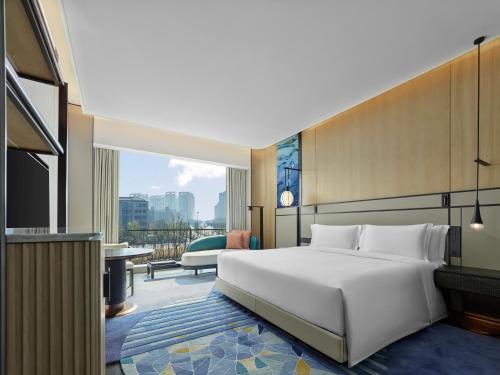 a hotel room with a bed and a balcony at Angsana Suzhou Shishan in Suzhou